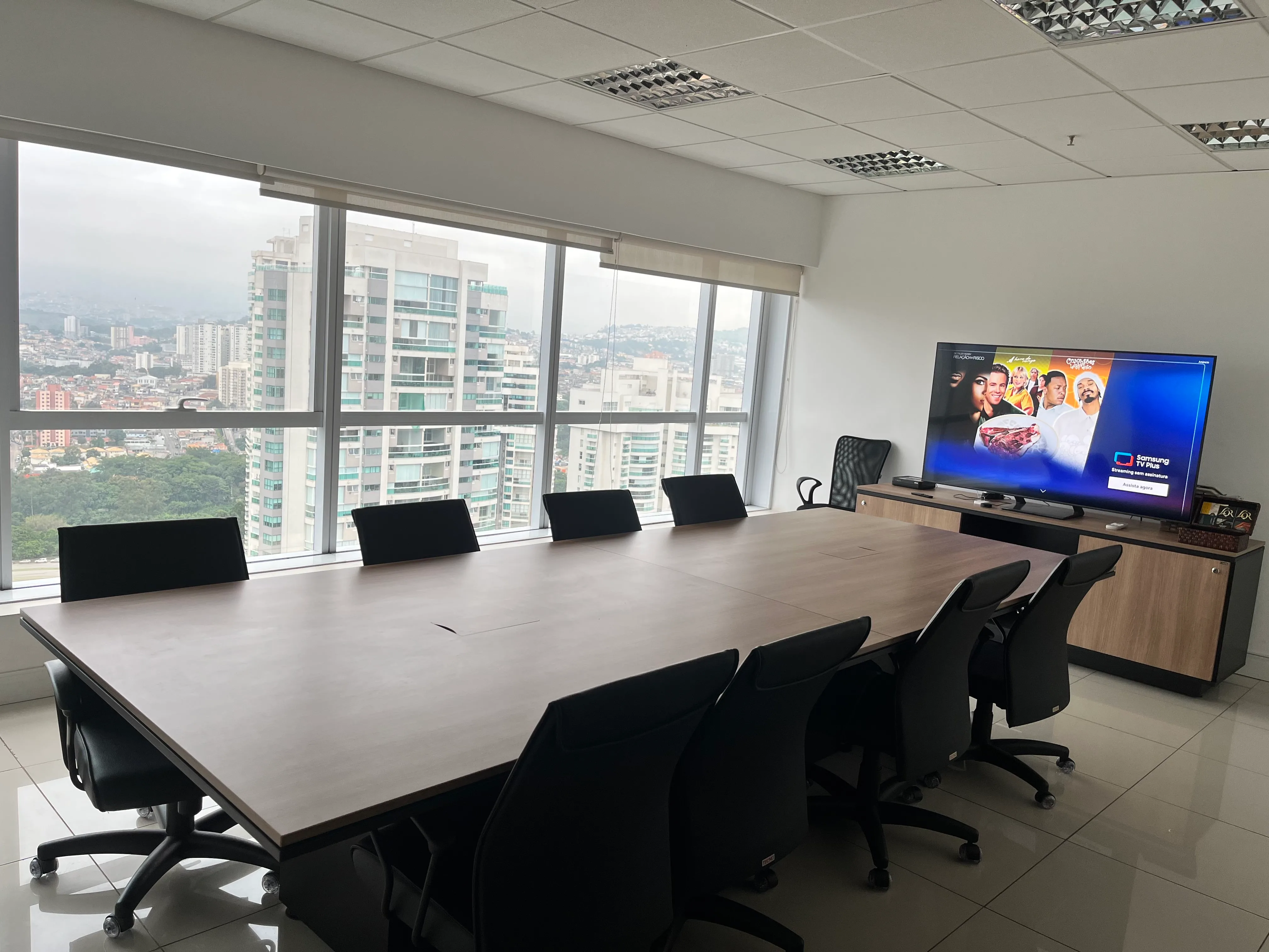 Mesa de reunião executiva da Sala K2 com vista panorâmica de Alphaville no 29º andar